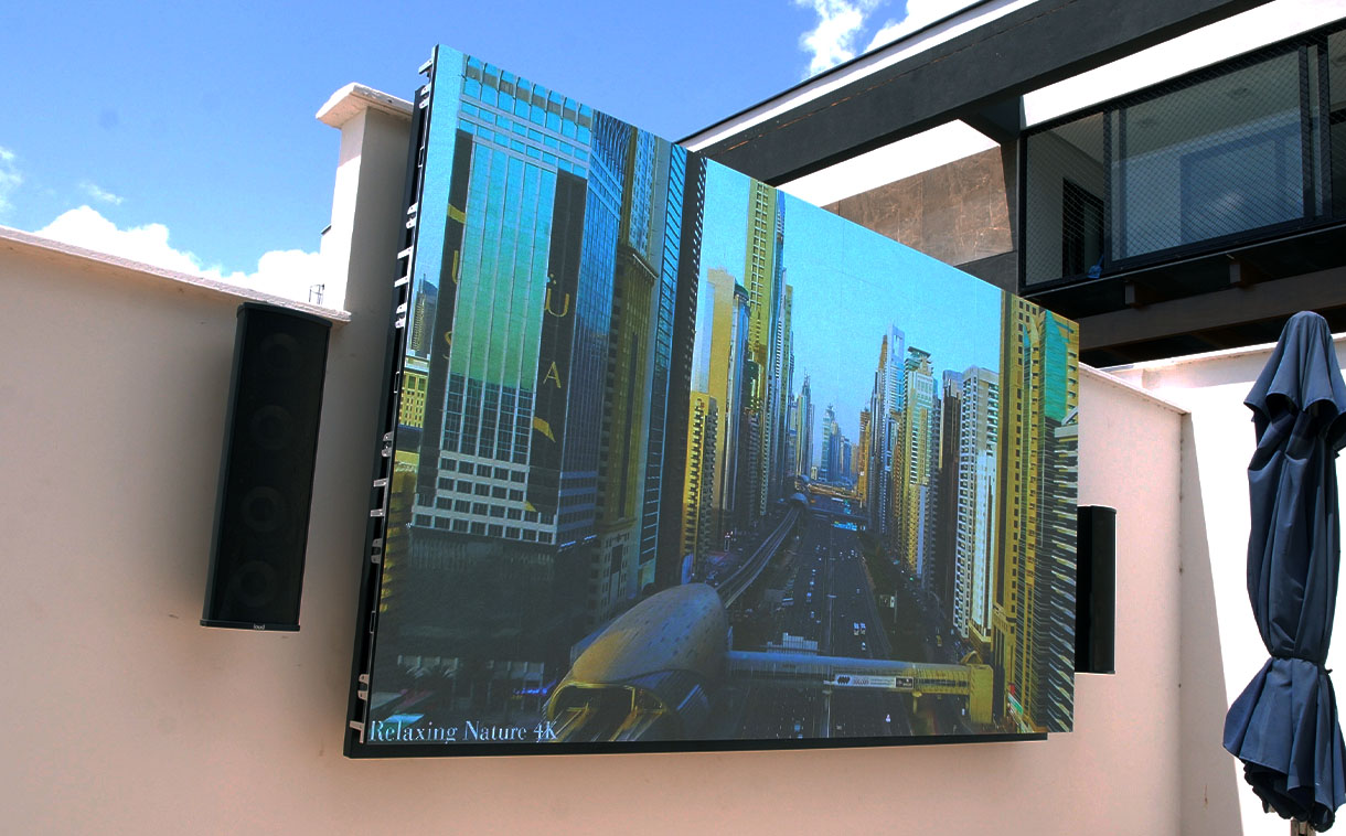 Painel de LED P2.5 em área externa exibindo imagens nítidas e coloridas ao lado da piscina